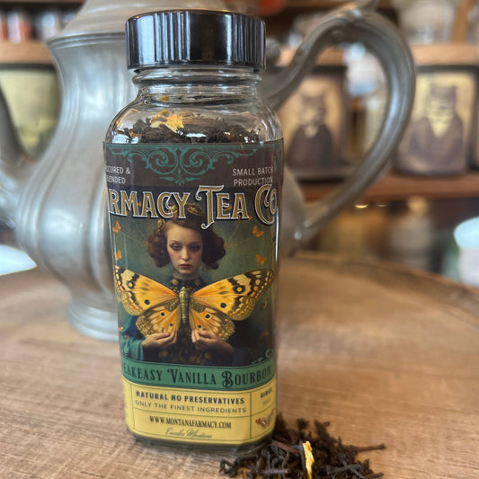 Bottle ofarmacy Tea Co. tea on a wooden surface with a teapot in the background