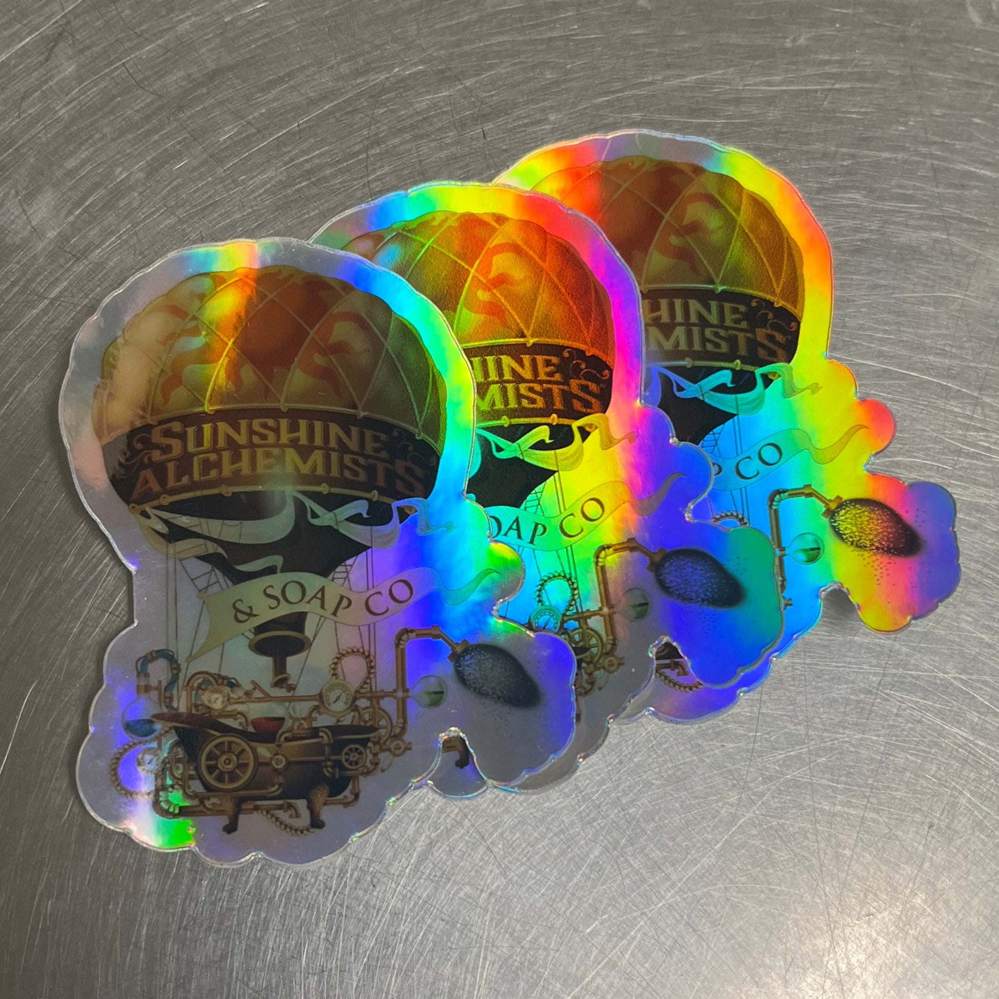 Holographic steampunk hot air balloon stickers on a metallic surface
