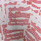 Stack of stickers with text 'Rebellious Defiant Extremely Non-Compliant' on a matching background.