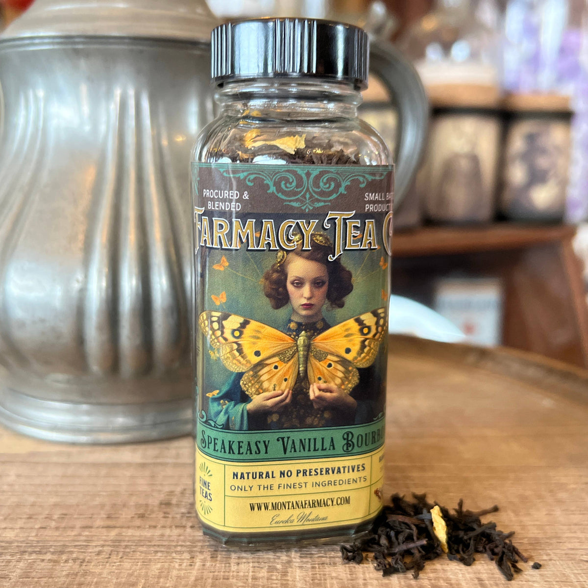Bottle of Pharmacy Tea on a wooden surface with a teapot in the background